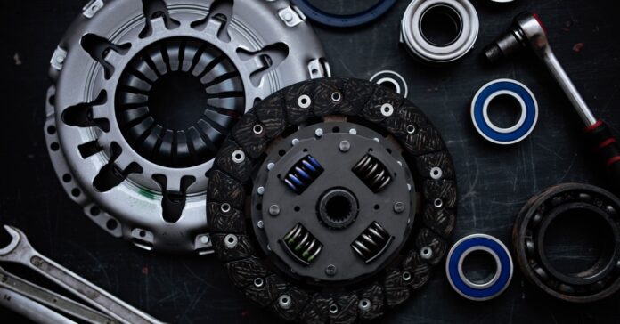 An overhead view of the components of a new car clutch kit, including the clutch disc, flywheel bearing, and more.