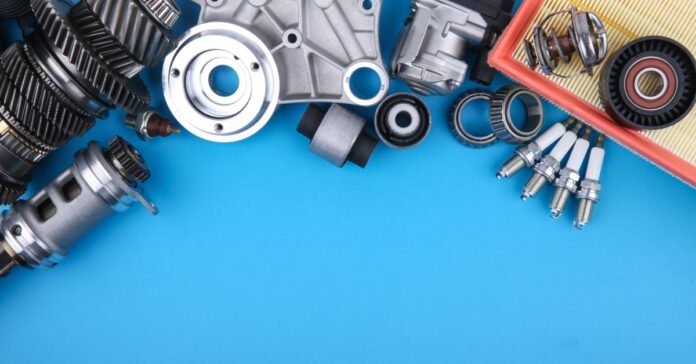 Car parts arranged along the top edge of a blue surface, leaving wide open copy space across the center and bottom.