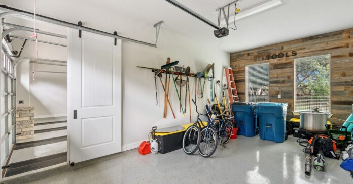 A clean residential garage has two sides separated by a wall, one side for parking cars, and the other side for storage.